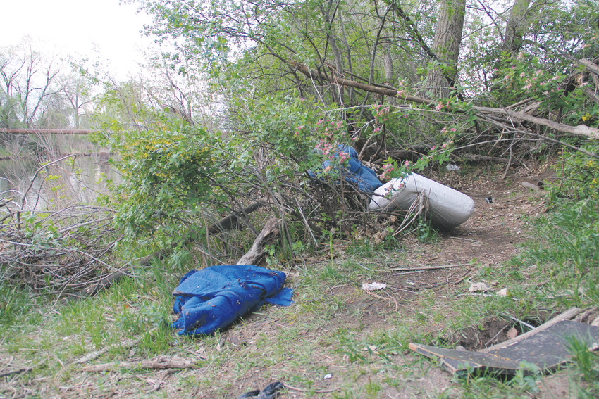 Blankets and a cushion drape the branches along the east banks of the South Platte River near West Dartmouth Avenue May 6. A worn walkway leads to the clearing.